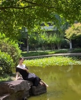 左小青光脚坐石头上拍照！旁边一池子脏水，胸口带超大宝石太贵气