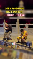 温馨! 小朋友与书摊爷爷路灯下默契看书……
