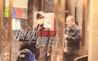 张国立吃火锅获众人簇拥，戴礼帽打扮时尚，与女友人握手笑容满面
