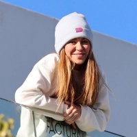 夏奇拉身穿印“女人不哭，女人赚钱”的卫衣，在阳台与歌迷打招呼