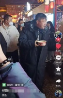 贾冰吃路边摊引起路人围观，一副黑老大的架势，满脸笑容打招呼