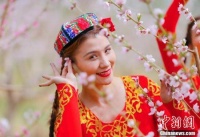 桃花树下新疆古丽笑靥如花