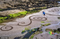 爱尔兰艺术家沙滩上勾勒艺术画作