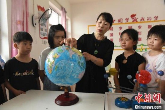 图为河北省深州市兵曹乡兵曹完全小学,航天员蔡旭哲的姐姐蔡旭娜(中)为学生们讲解航天知识。袁佳凯 摄