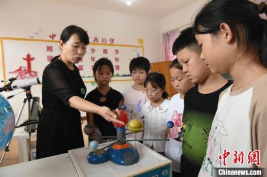 图为河北省深州市兵曹乡兵曹完全小学,航天员蔡旭哲的姐姐蔡旭娜(左一)为学生们讲解航天知识。袁佳凯 摄