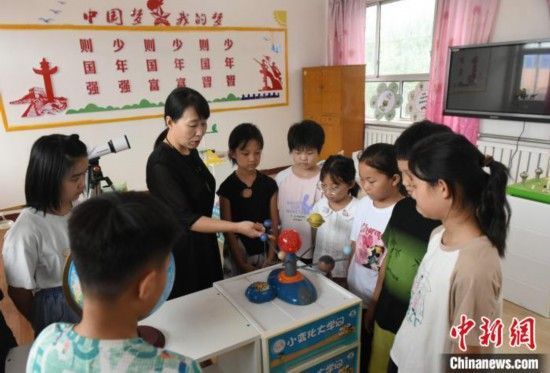 图为河北省深州市兵曹乡兵曹完全小学,航天员蔡旭哲的姐姐蔡旭娜(左三)为学生们讲解航天知识。袁佳凯 摄