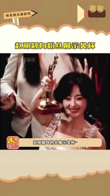 向粉丝展示奖杯,笑容甜美,这是她第二次获得金鹰奖视后…