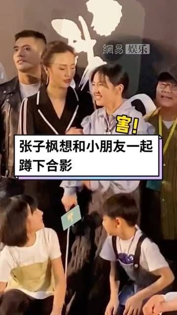 想和小朋友们一起蹲下来合影,却被突然拉住,妹妹不好意思地笑了…