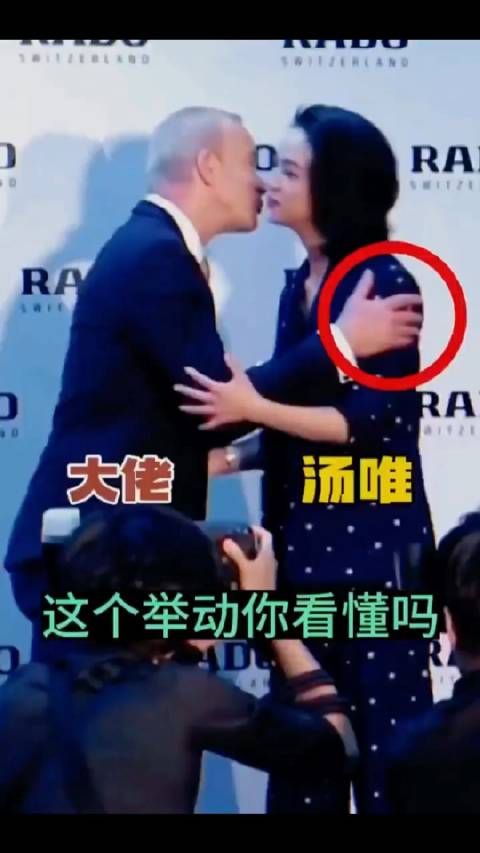 注意看,汤唯伸手与男子握手,男子却用双手抓住汤唯的胳膊,强行跟她贴面…
