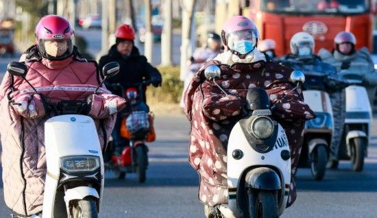 2月8日，在江苏省淮安市淮安区，市民骑车出行。受寒潮影响，多地迎来大风降温天气。新华社发（赵启瑞摄）