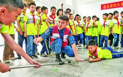 5月7日，红十字会工作人员在湖南省永州市道县第四小学为学生们指导防溺水救援技能。