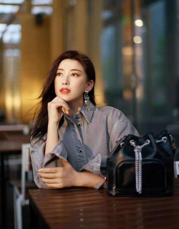 朱珠单手托腮，做沉思状。