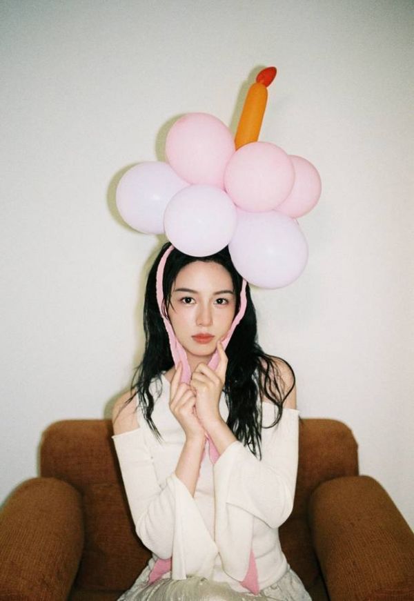 搜狐娱乐讯 5月20日，周也一组美照释出，今天是她的生日，照片中她穿着白色露肩上衣青春活力，头顶戴着气球可爱灵动。