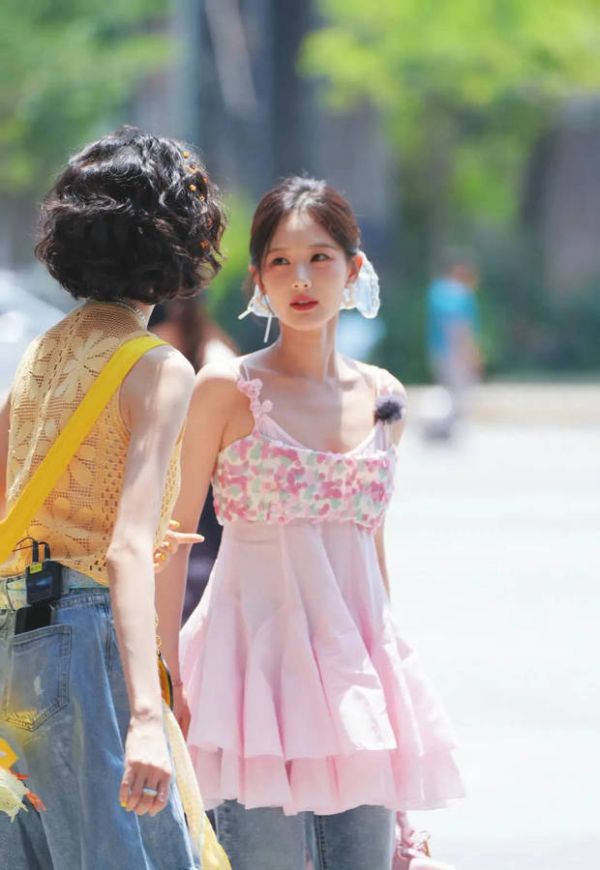 搜狐娱乐讯 6月11日，李一桐一组新综艺路透释出，照片中她穿粉色吊带上衣甜美灵动，蓝色发带青春活力，在阳光下像草莓小蛋糕。