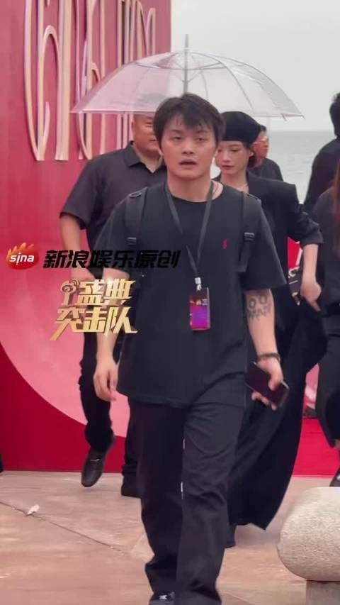 演员李庚希亮相红毯,头戴贝雷帽,身着黑色长裙,微笑点头回应