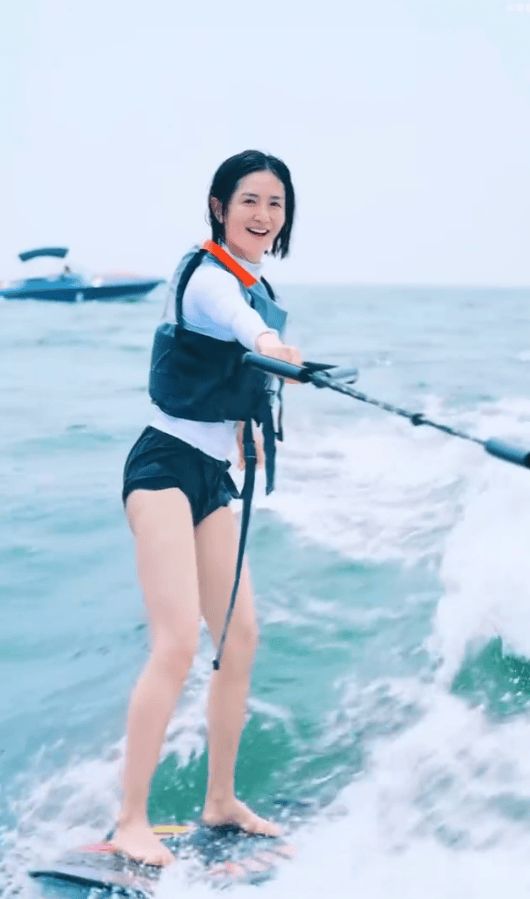 谢娜单手拉着冲浪用的绳子。