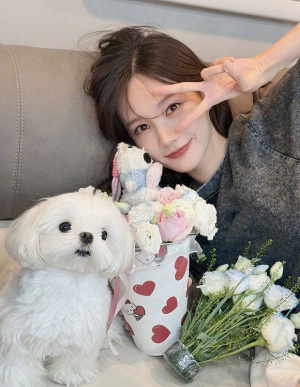 李一桐抱着花和小狗合影。
