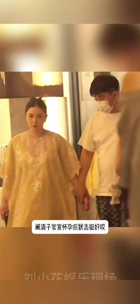 阚清子挺孕肚和老公牵手散步