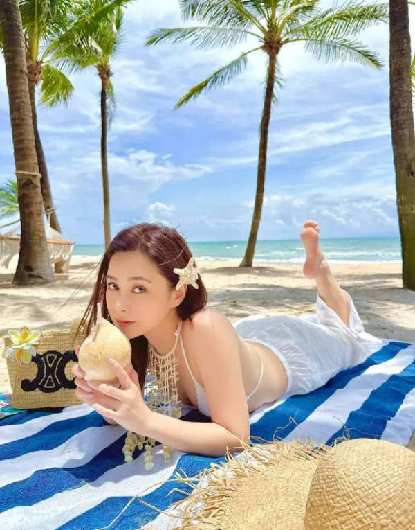 钟欣潼手拿椰子，甜美俏皮。