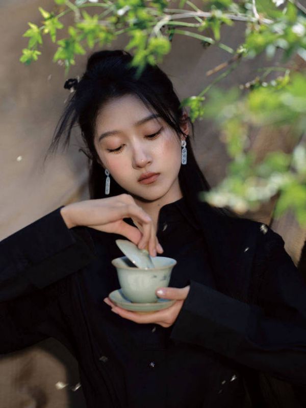 关晓彤手掀茶盖，神态专注。