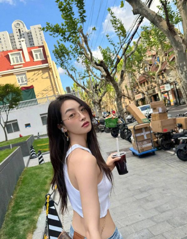 宋茜手捧咖啡散步，十分惬意。