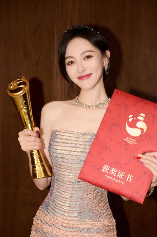 唐嫣拿着奖杯，笑容甜美。