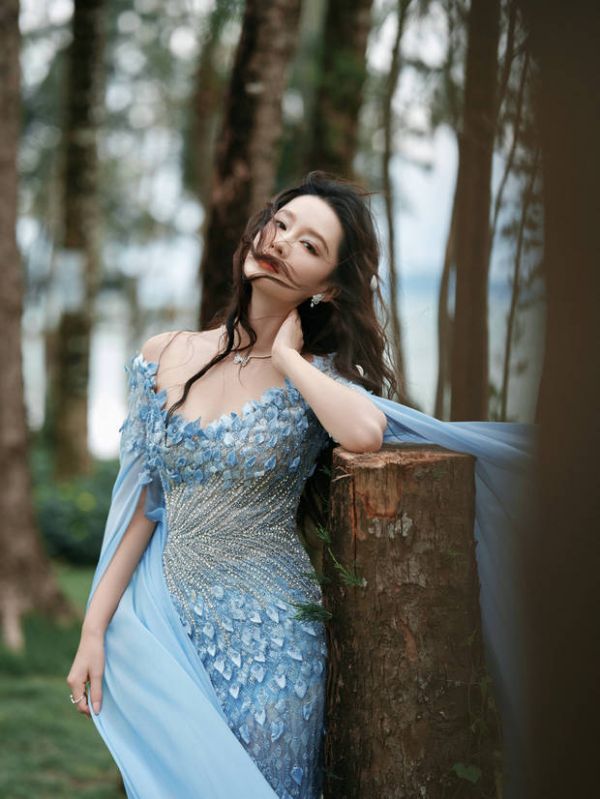 搜狐娱乐讯 10月28日，李沁的一组盛典造型释出。图中，李沁穿着蓝色礼裙，卷发造型优雅俏皮。