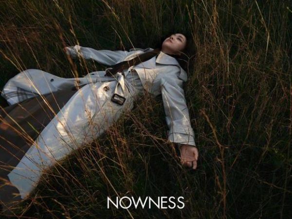 汤唯躺在草地上，慵懒松弛。