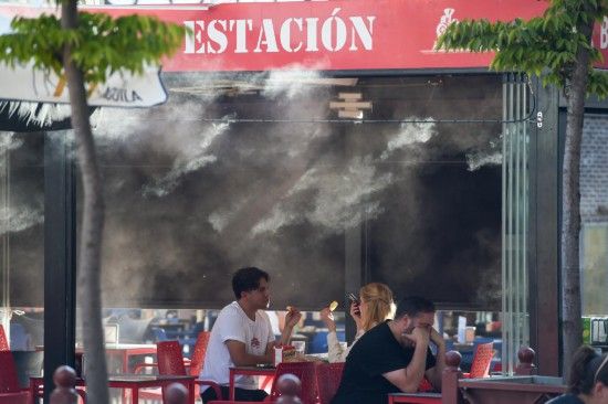 2025年9月17日,在西班牙马德里,顾客在水雾装置附近用餐。新华社发(古斯塔沃·巴连特摄)