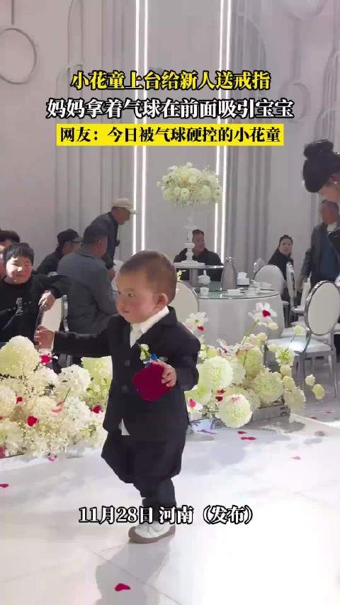 小花童上台给新人送戒指,妈妈拿着气球在前面吸引宝宝