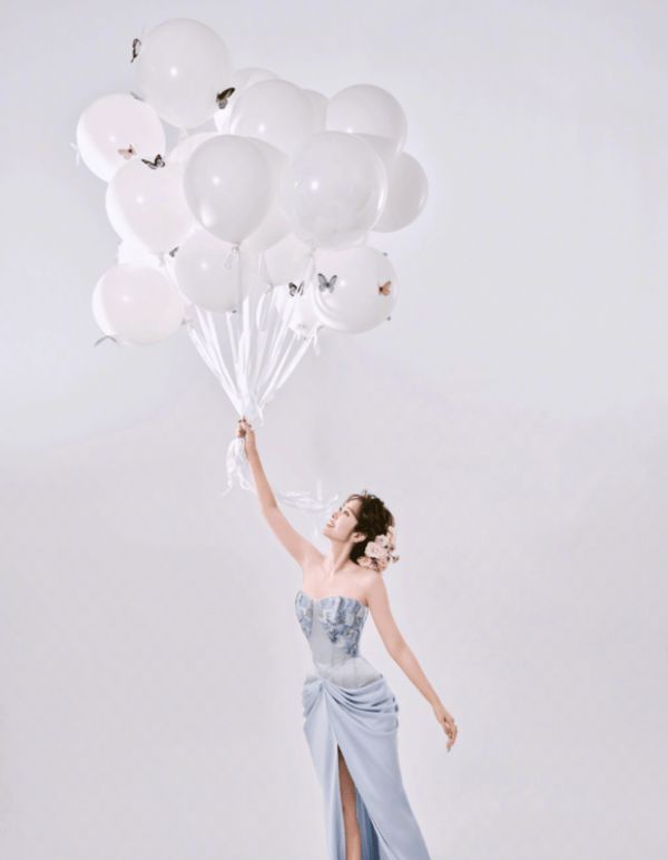 唐艺昕手持白色气球,背景的简约色调衬出礼裙的清新。