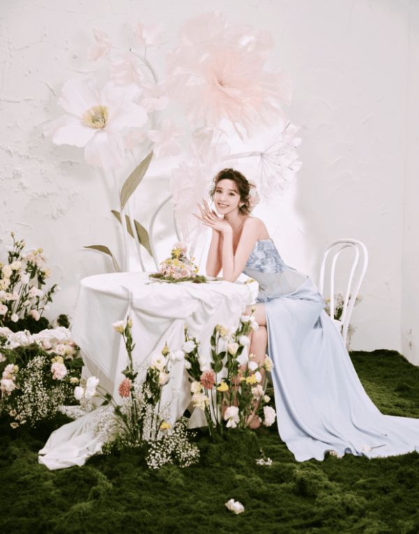 唐艺昕坐于花丛布景中,美丽大气。