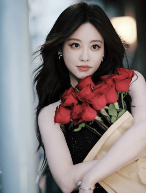 祝绪丹怀抱簇簇红玫瑰,黑色吊带裙衬得肤白明艳。