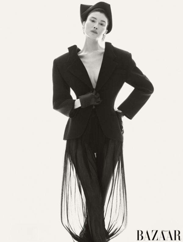 何穗黑调西装套装亮相，双手叉腰的姿态干练冷冽，裙摆细节添设计感。