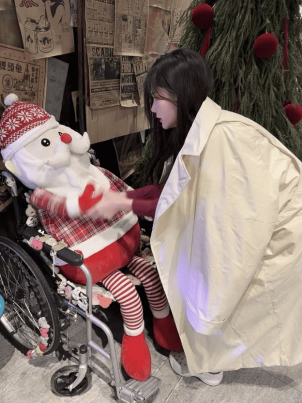 李一桐俯身轻触玩偶,姿态温柔舒展。