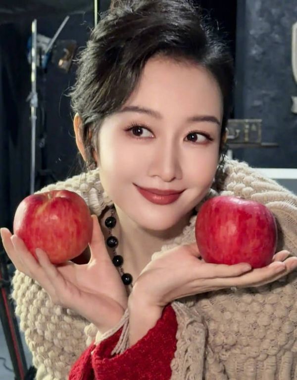 王鸥手拿两个苹果拍照。