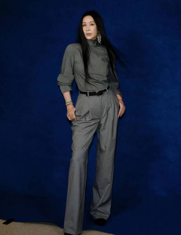 搜狐娱乐讯 28日，那英最新拍摄的写真大片释出，她一身灰色Look显优雅成熟，戴超大耳饰时髦吸睛，长发及腰超有范儿。