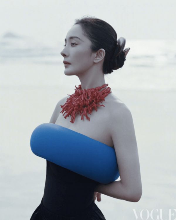 杨幂身着蓝调造型，搭配红饰颈链，侧颜线条精致柔和。