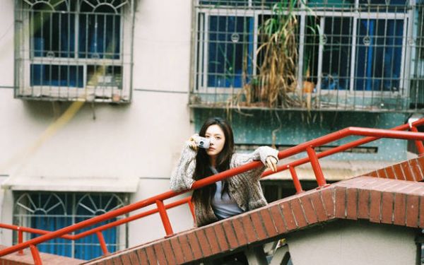 蔡文静手拿卡片相机，十分俏皮。