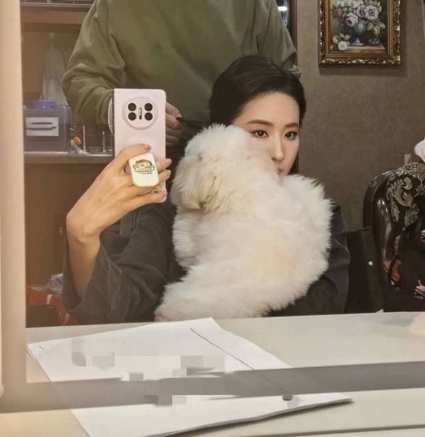 搜狐娱乐讯 1月6日，刘亦菲在社交平台分享一组随拍，照片里的她抱着小狗，对镜自拍，状态松弛。