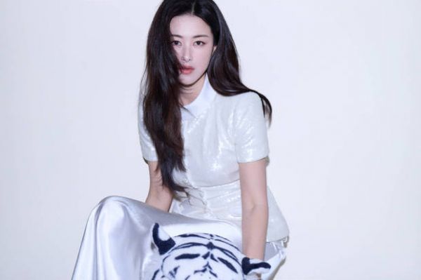 朱珠白亮片上衣搭缎面裙，手戴钻饰，姿态优雅松弛。