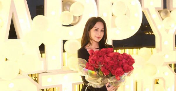 阿娇穿吊带裙，捧着玫瑰花束拍照，十分俏丽多姿！
