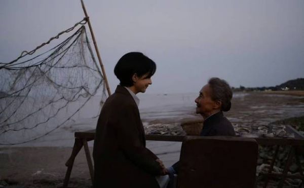 二人相视而笑，祖孙情谊在海边流淌。