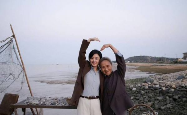 二人抬手比心，笑容灿烂。