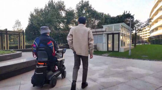 2025年,四肢瘫痪患者(左)通过脑机接口系统“意念”控制轮椅。(中国科学院脑科学与智能技术卓越创新中心供图)