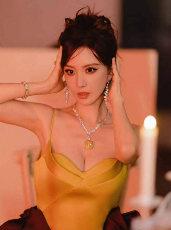 张萌穿黄色吊带裙，红绸装饰造型吸睛。