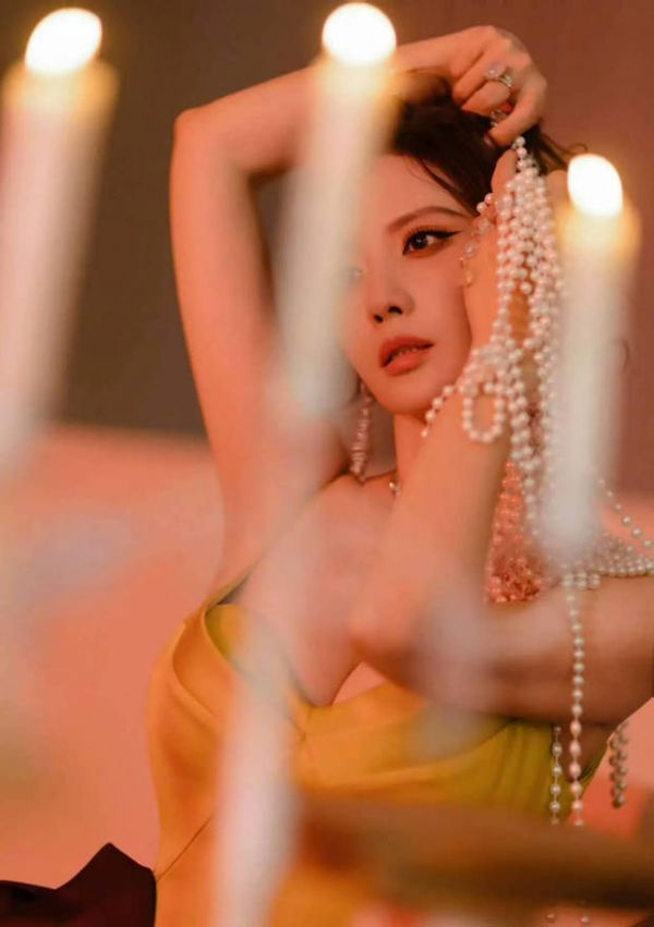 张萌撑腮凝望镜头，烛光氛围慵懒松弛。