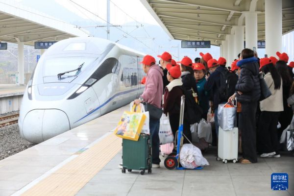 2月22日，务工人员及家属在凯里南站准备乘坐返岗务工专列。新华社发（王波摄）