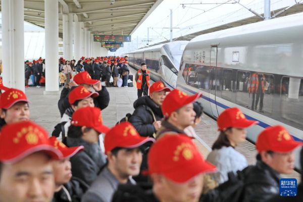 2月22日，务工人员及家属在凯里南站准备乘坐返岗务工专列。新华社发（张贵忠摄）