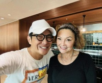 张柏芝母亲戴莎妮罕露脸，在街边茶档喝茶聊天，怀抱爱犬生活惬意